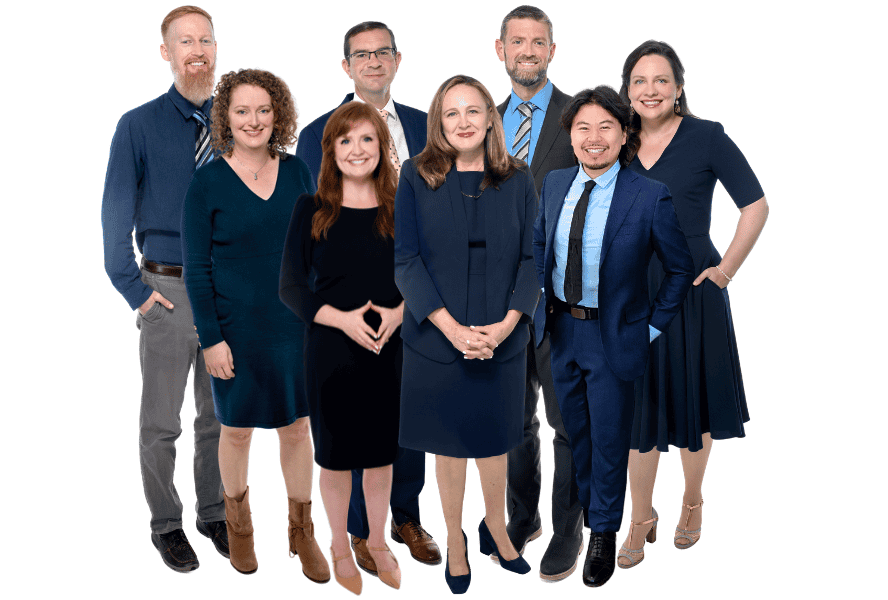 Group of diverse professionals in business attire smiling for the camera.